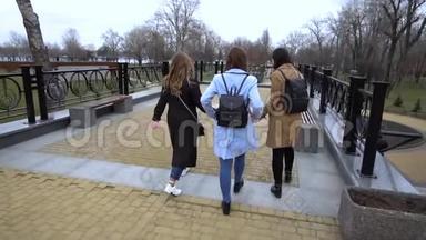 女孩的友谊。 三个年轻漂亮的女孩在城市里走来走去。 他们很开心。 女孩们很高兴见面。 他们走了